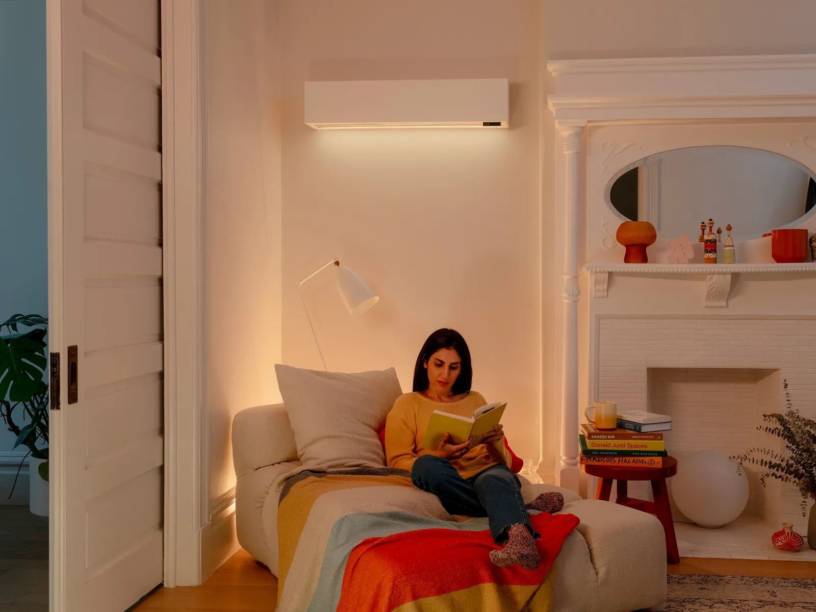 Woman relaxing on her couch under a wall-mounted mini-split