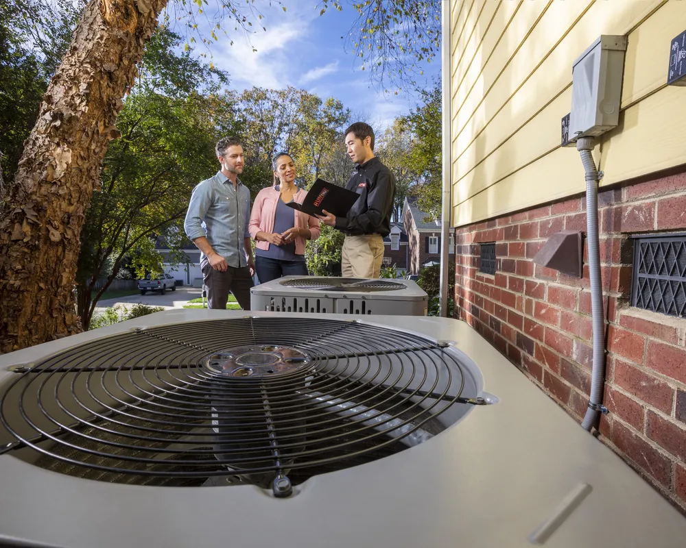 Technician showing homeowners their outdoor AC unit