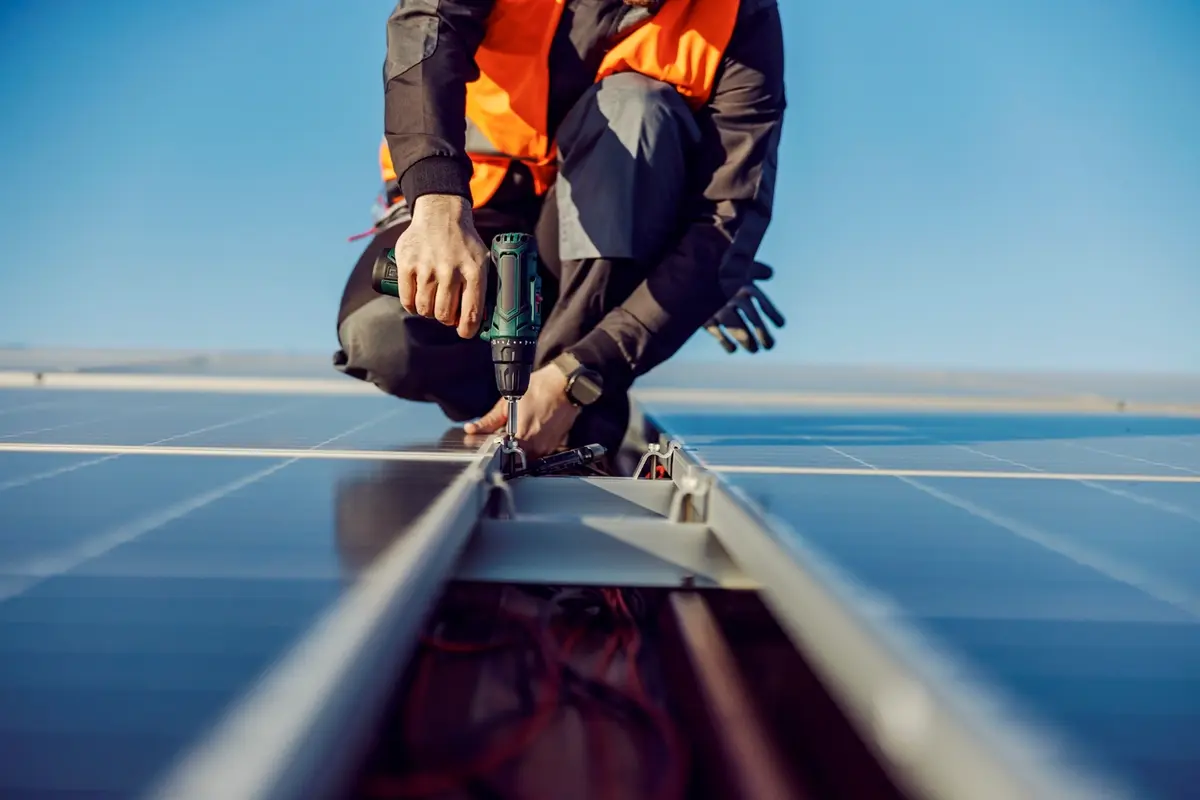 Technician working on the mounting rails of a rooftop solar array