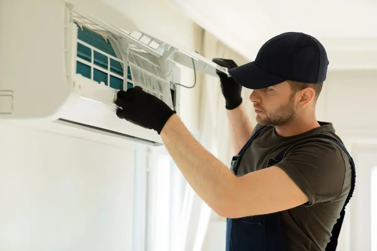 Technician servicing a wall-mounted ductless mini-split indoor unit